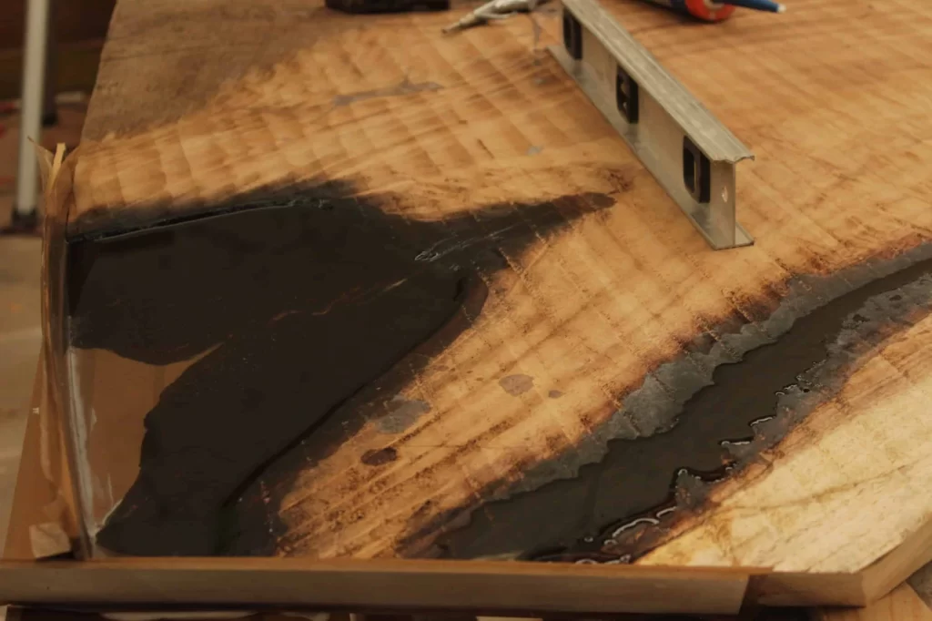 Esquina de mesa de parota Acercamiento a esquina de mesa de parota con resina